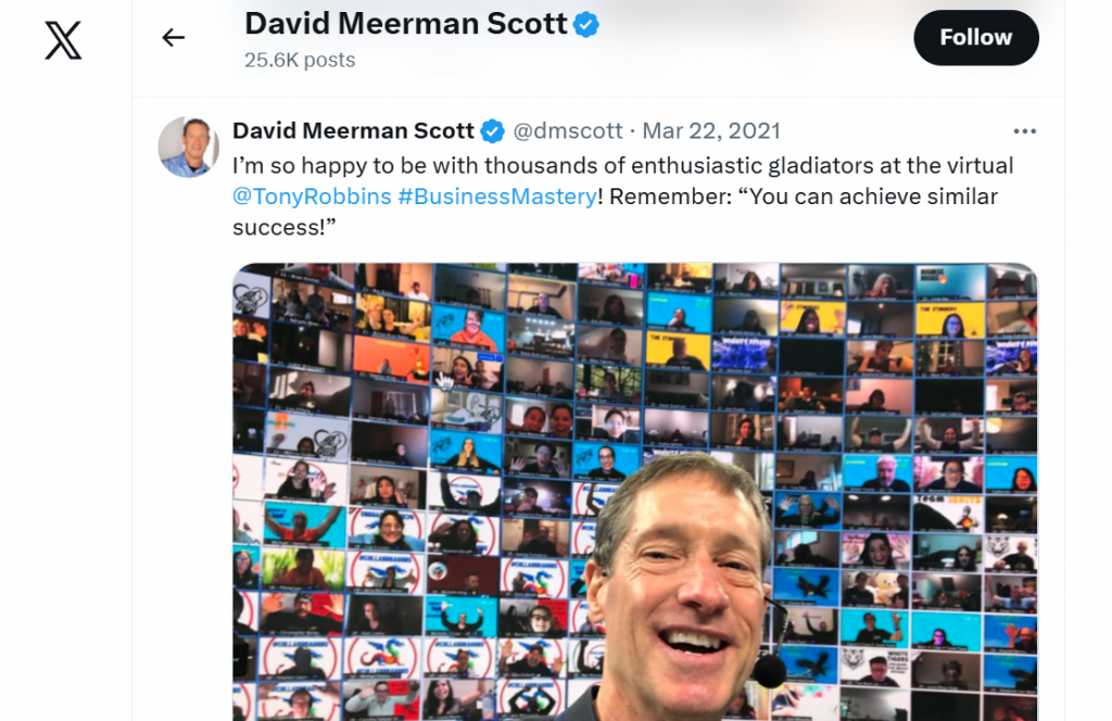 Ein Screenshot eines Twitter-Posts mit einem Hashtag, der einen Mann zeigt, der vor einer Videowand mit virtuellen Teilnehmern lächelt.