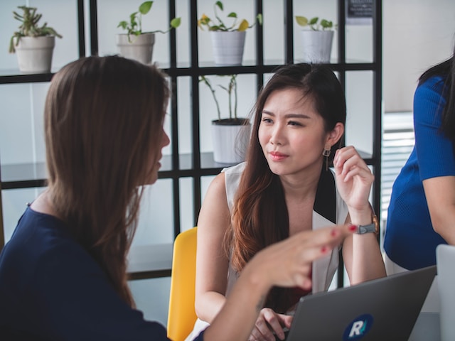 A woman explaining to another lady why she should log out of her Twitter account.